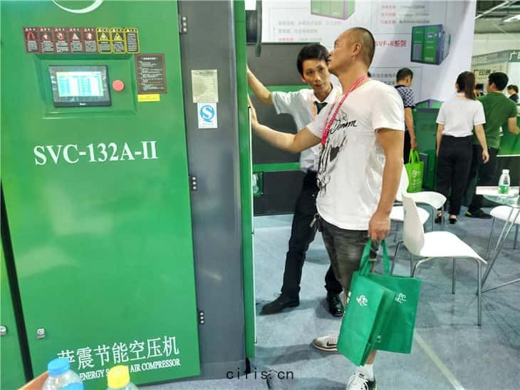 參觀者在薩(sà)震132kw永磁變頻雙(shuāng)級(jí)壓縮空壓機機(jī)器旁駐(zhù)足(zú)咨(zī)詢
